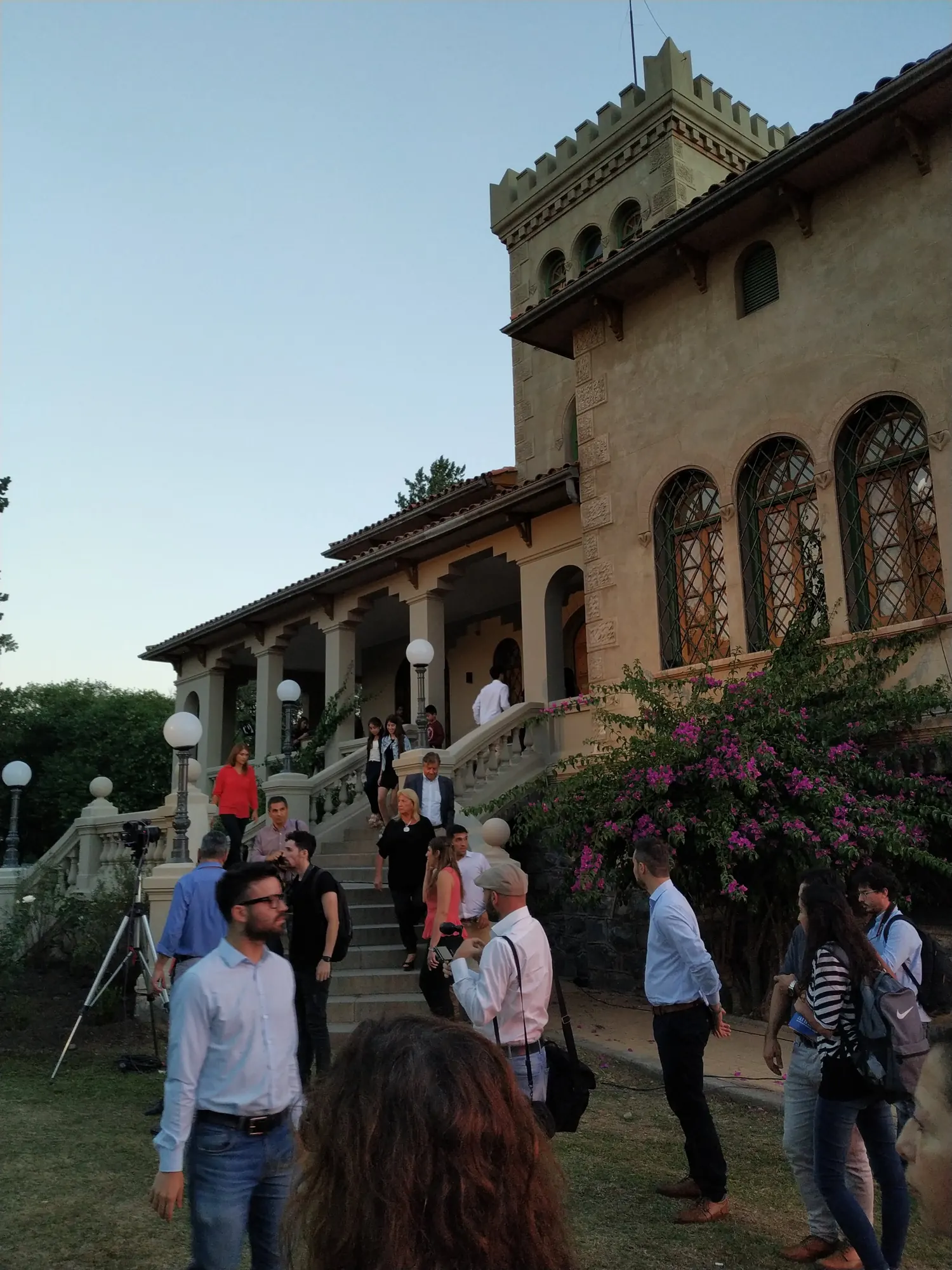 Casona con torre y público en el jardín